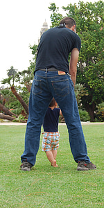 man holding hands of boy while walking at daytime thumbnail