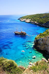 Brown and White Boat on Blue Seashore thumbnail