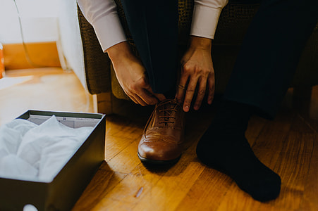 person tying brown leather dress shoe thumbnail