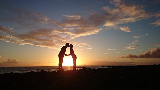 silhouette of man kissing woman on beach thumbnail