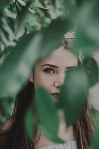 woman peeking on green leaves thumbnail