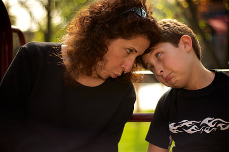 boy in black shirt beside woman sitting on bench thumbnail