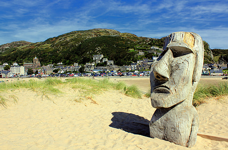 gray concrete statue on seashore near buildings at daytime thumbnail