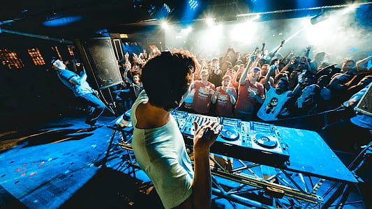 DJ playing music near crowded people at nighttime thumbnail