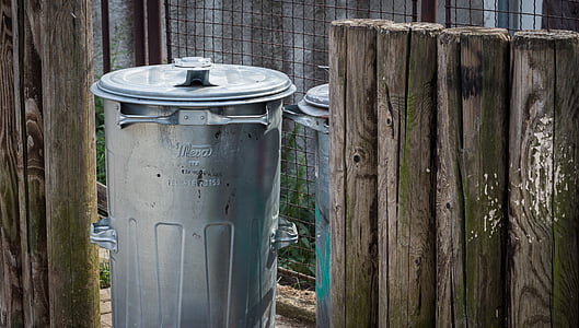 gray metal trash bin near fence thumbnail