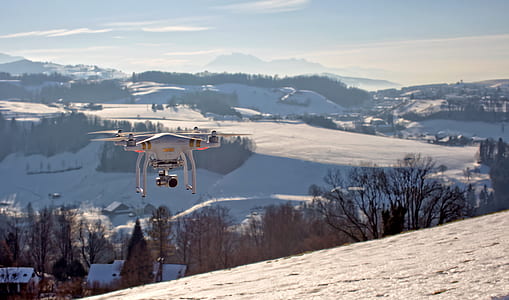 flying DJI Phantom drone on snow-covered field thumbnail
