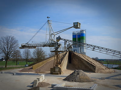 gray and brown crane besides industrial tanks thumbnail
