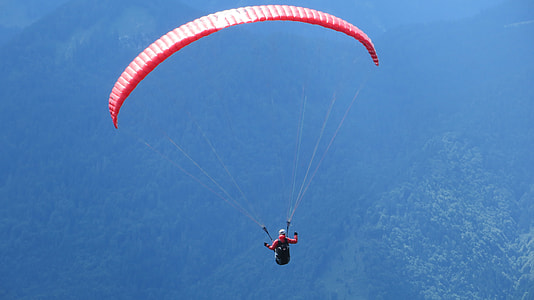 person parachuting above body of water during daytime thumbnail