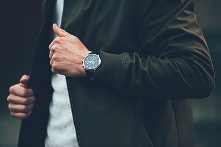 man in black zip-up jacket and round black watch thumbnail