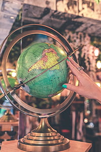 person holding green desk globe thumbnail