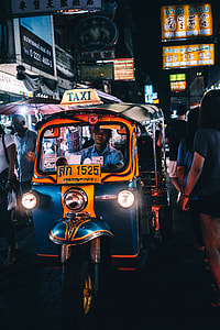 man riding blue and yellow auto rickshaw thumbnail