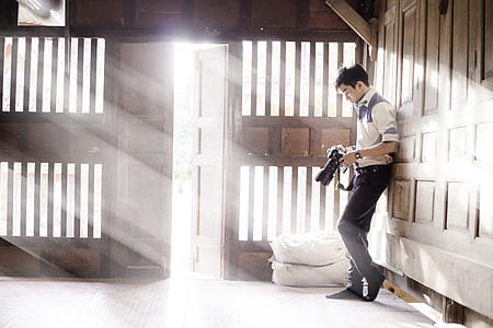 man holding camera beside open door thumbnail