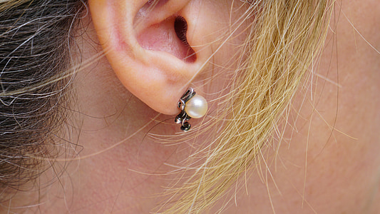 person taking a photo of unpaired white pearl stud earring thumbnail