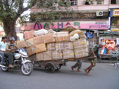 two person carrying brown wooden wagon full of brown cardboard boxes thumbnail