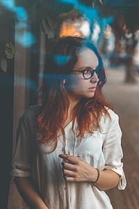 woman wearing blouse with eyeglasses standing while looking on her left side thumbnail