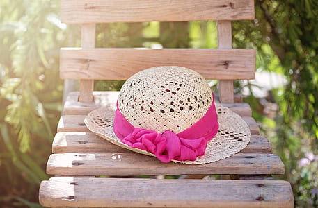 brown and pin hat on brown wooden chair thumbnail