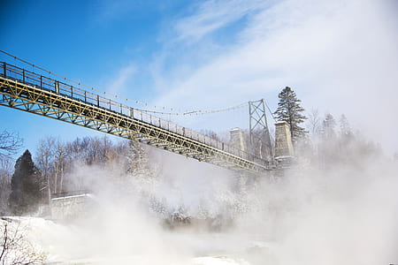 photo of brown bridge near trees and snow field thumbnail