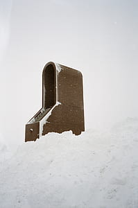 arch-shaped brown mailbox covered white snow thumbnail