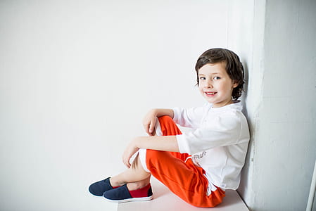 boy wearing white long-sleeved shirt and red pants thumbnail