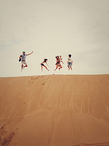 people doing jump shot on desert during daytime thumbnail