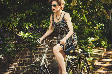 woman riding bicycle near green leafed tree thumbnail