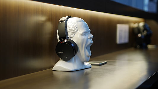 black wireless headphones on white person's head figurine thumbnail