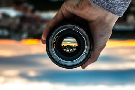 person holding camera lens thumbnail