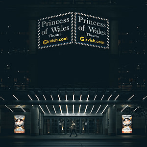 woman walking under Princess of Wales signage during nighttime thumbnail