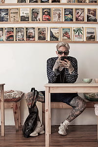 man sitting on brown wooden bench holding smartphone thumbnail