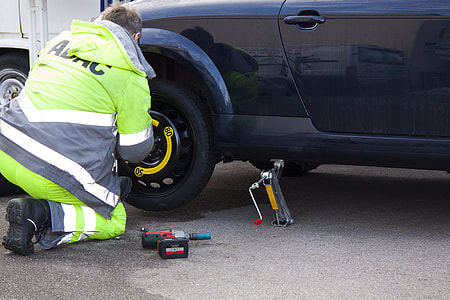 man kneeling near black vehicle thumbnail
