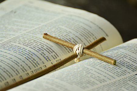 brown twig cross in between book pages thumbnail