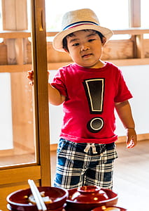 boy holding door near bowls inside room thumbnail