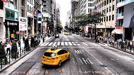 photo of a yellow cab on road between high-rise buildings thumbnail