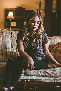 woman sitting on brown and white floral padded chair thumbnail