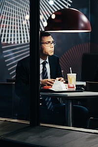 man sitting near table with McDonald cup in room thumbnail