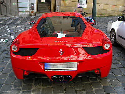 red Ferrari 458 Italia parked in front of brown building thumbnail