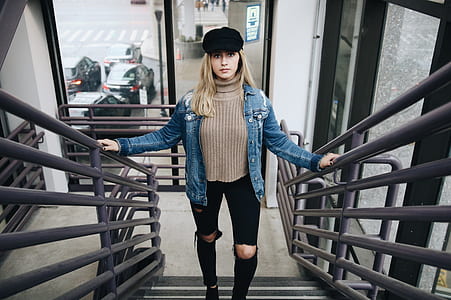 woman standing on gray metal staircase during daytime thumbnail