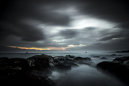 rock formations under cloudy sky during sunset thumbnail