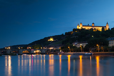 castle on hill near body of water during night time thumbnail