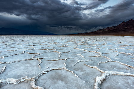 plain white terrain with mountain in distance under white clouds thumbnail