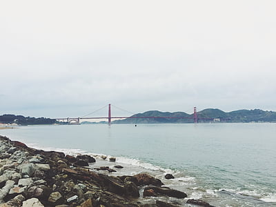 red metal bridge near mountain thumbnail