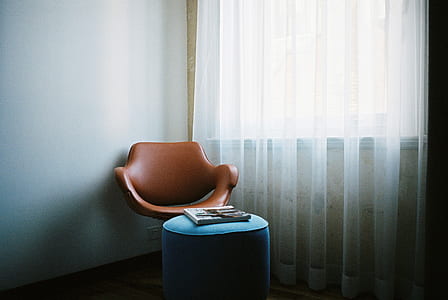 brown leather chair placed near white curtain thumbnail