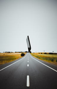 Android smartphone hanging on road between bush plant thumbnail