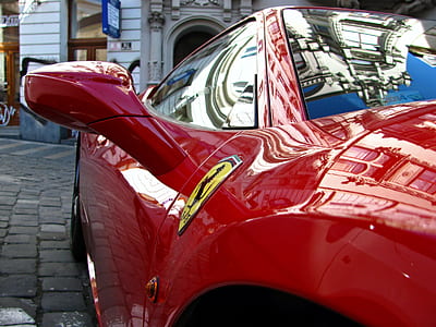 red Ferrari sports car on gray pavement thumbnail
