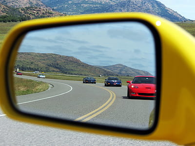 five assorted-color sports vehicles reflecting in side mirror thumbnail