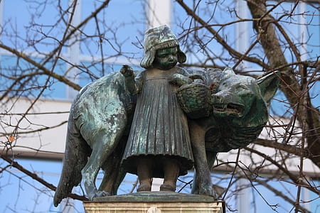 girl standing beside dog themed statue selective focus photography thumbnail
