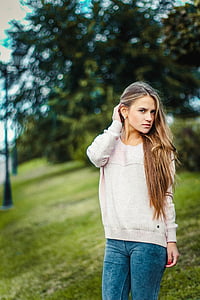 woman wearing sweater standing on green field thumbnail