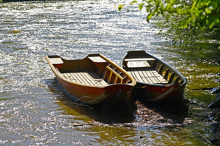 two gray and brown boats near green leafed tree thumbnail