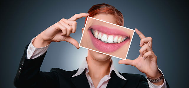 woman holding photo of teeth thumbnail