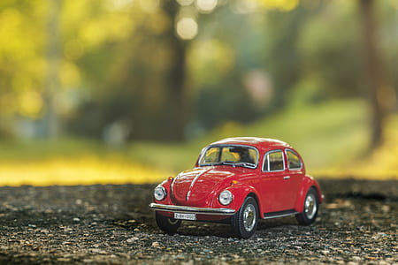 stilt shift red Volkswagen Beetle scale model selective focus photography thumbnail